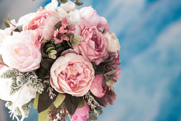 pale pink bouquet of peony roses on a blue wall background