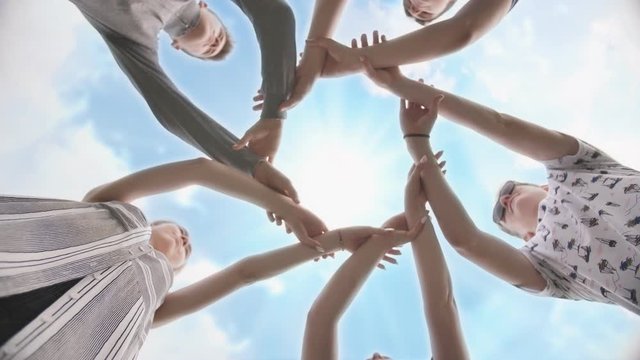 Friends join their hands in a circle. The concept of strong friendship.
