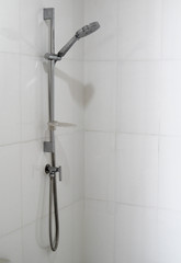 Modern shower head on white wall in the bathroom.