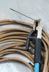 Welding electrode holder with electrode wire on the floor.