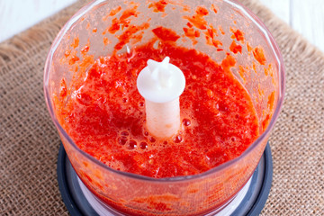 Preparing an red tomato cocktail in a blender