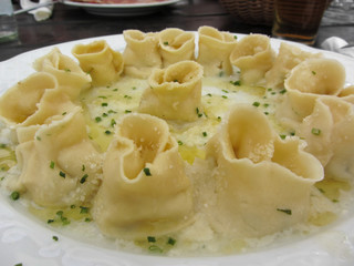 Herbs and ricotta stuffed Tortellini pasta in abundantly melted butter with chives and mountain cheese . Alto Adige, Italy