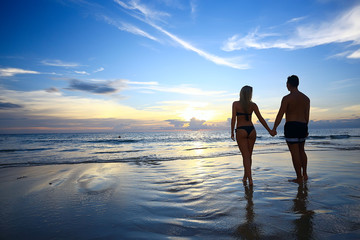 Fototapeta premium silhouette in love sunset sea / newlyweds in honeymoon at sea, vacation luck summer sea beach, silhouette couple at sunset