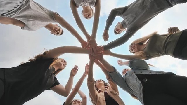Friends join their hands as a sign of their strong friendship.