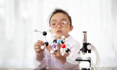 Young scientist girl holding the molecular structure to do science