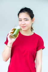 Woman in red shirt holding a glass of green tea