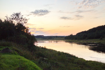 Sunset by the river in the summer countryside