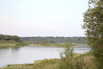 by the river in the countryside on a summer evening