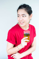 Woman in red shirt is sitting and holding a glass of green tea