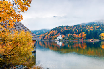 Fototapeta na wymiar Foggy autumn view of Grundlsee lake. Romantic morning scene of Brauhof village, Styria stare of Austria, Europe. Colorful view of Alps. Traveling concept background. Orton Effect.