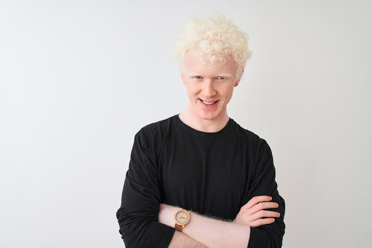 Young albino blond man wearing black t-shirt standing over isolated white background happy face smiling with crossed arms looking at the camera. Positive person.