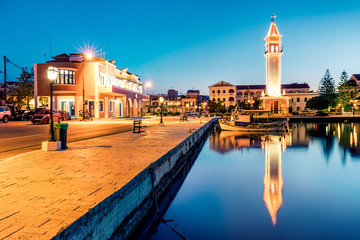 Naklejka premium Colorful evening view of Greece island Zakynthos. Illuminated spring scene of town hall and empty street of Zakynthos city, Ionian Sea, Greece, Europe. Traveling concept background.