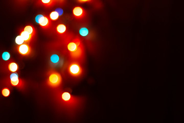 Blurred multicolor lights, dark background with space for text. Abstracted Christmas and New Year celebration template