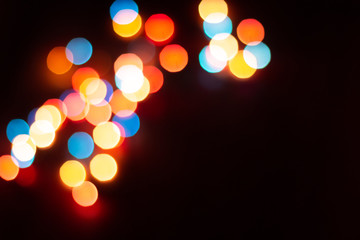 Blurred multicolor lights, dark background with space for text. Abstracted Christmas and New Year celebration template