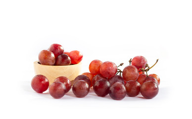Closeup of red grapes with red grapes in wooden bowl  isolated on white background