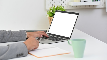 Closeup businessman's hand using mockup laptop computer on table.