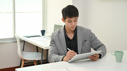 Young asian business using tablet and stylus working in office workplace.