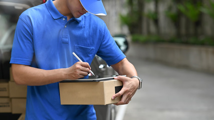 Delivery man checking list on tablet with stylus pen.
