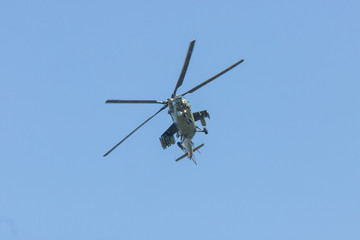 Fototapeta na wymiar A military helicopter flying in the blue sky