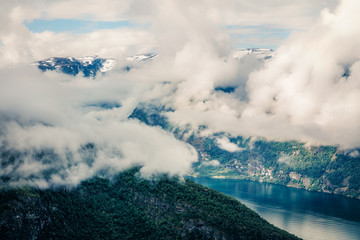 Foggy summer view of Sognefjorden fjord. Picturesque morning scene with Aurlandsvangen village, Norway. Traveling concept background. Artistic style post processed photo.