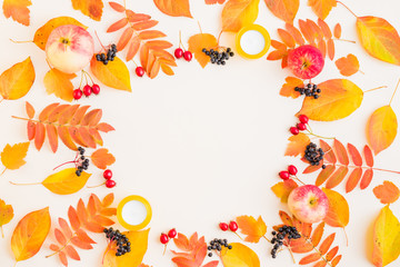 Obraz na płótnie Canvas Flat lay frame with colorful autumn leaves and berries on a white background
