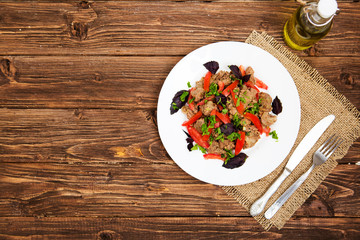 Fried liver with onion and tomatoes on wooden background