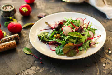 salad with radishes and mix lettuce leaves, appetizer, snack. food background. top view