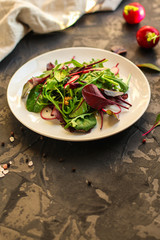 salad with radishes and mix lettuce leaves, appetizer, snack. food background. top view