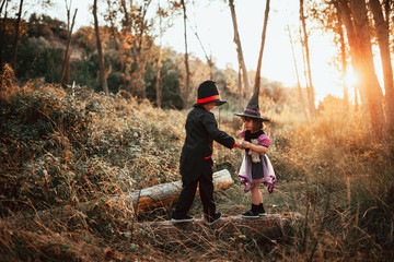 Two children disguised for Halloween in the woods