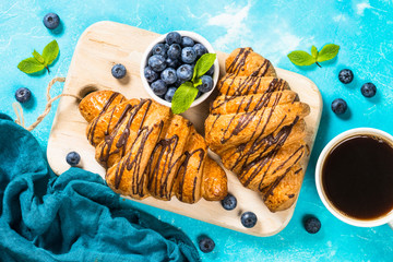 Croissant with fresh berries and cup of coffee.