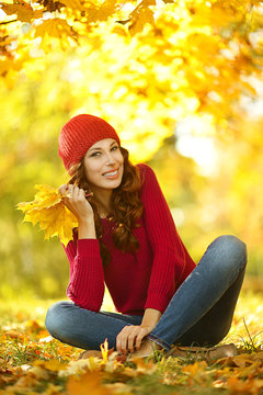 Portrait of beautiful young woman posing in autumn park
