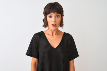 Young beautiful woman wearing black t-shirt standing over isolated white background afraid and shocked with surprise expression, fear and excited face.
