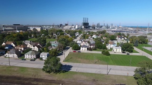Aerial video of East Chicago, Illinois neighborhood with oil refinery in distance on Lake Michigan