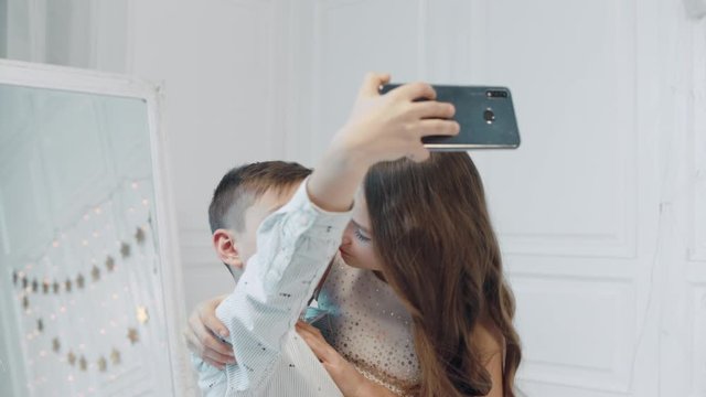 Smiling boy and girl making selfie photos together.