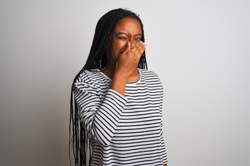 Young african american woman wearing striped t-shirt standing over isolated white background...