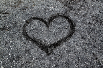 Drawing of a heart on the sand on a black beach in Iceland