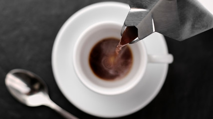 pour coffee from a coffee maker into a cup, close up