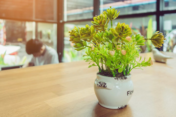 Artificial plants or plastic tree on table for decoration and welcome for customers in coffee shop.