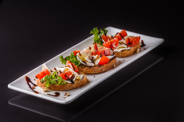 Bruschetta with tomatoes, lettuce, camambert, balsamic vinegar