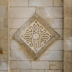 Square floral pattern unit carved into the exterior ancient stone wall of Al Hakim Mosque, Moez Street, Old Cairo, Egypt
