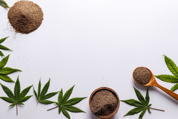 Organic bran from seed cannabis, a healthy natural product, located on a white background with hemp leaves, horizontal orientation, copy space