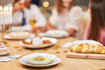 Hanukkah dinner. Family gathered around the table with traditional dishes