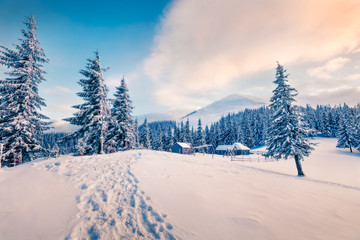 Beautiful winter sunset in Carpathian abandoned village. Frosty outdoor scene, Happy New Year celebration concept. Artistic style post processed photo. Orton Effect.