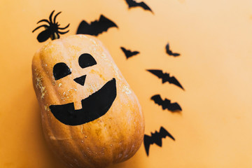 Pumpkin jack lantern and black bats, ghost, spider paper decorations on yellow background, copy...