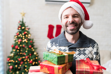 Smiling Mid Adult Male With Christmas Gifts At Home