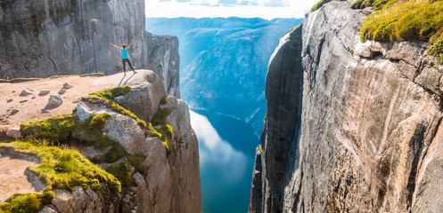 Woman on Kjeragbolten Travel in Norway Kjerag mountains, extreme vacations, adventure, tourist, happy emotions, success concept