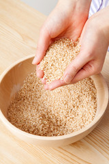 若い女性が掬う玄米