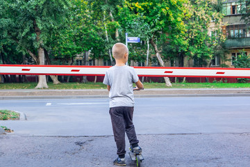 boy on a scooter near the barrier
