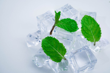 ice cubes with green leaves mint on white background