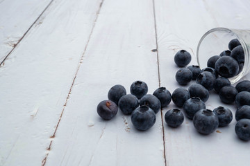 blueberries in glass shot on white wooden  background, fruit flavor concept